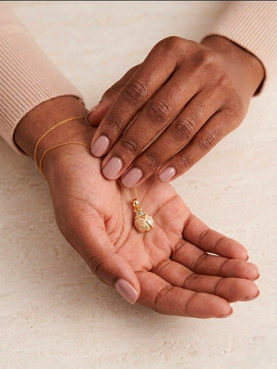 Dije de catarina en color blanco y dorado