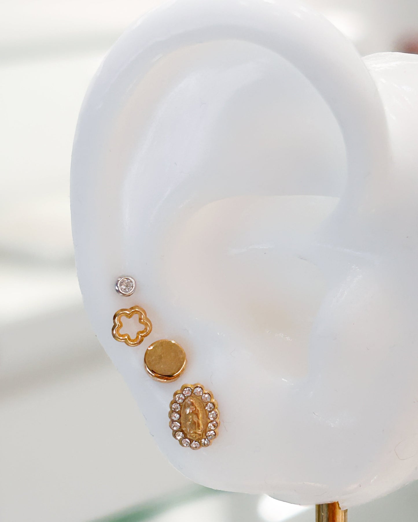 Arete tipo broquel de forma circular plana con acabado pulido en oro 10k