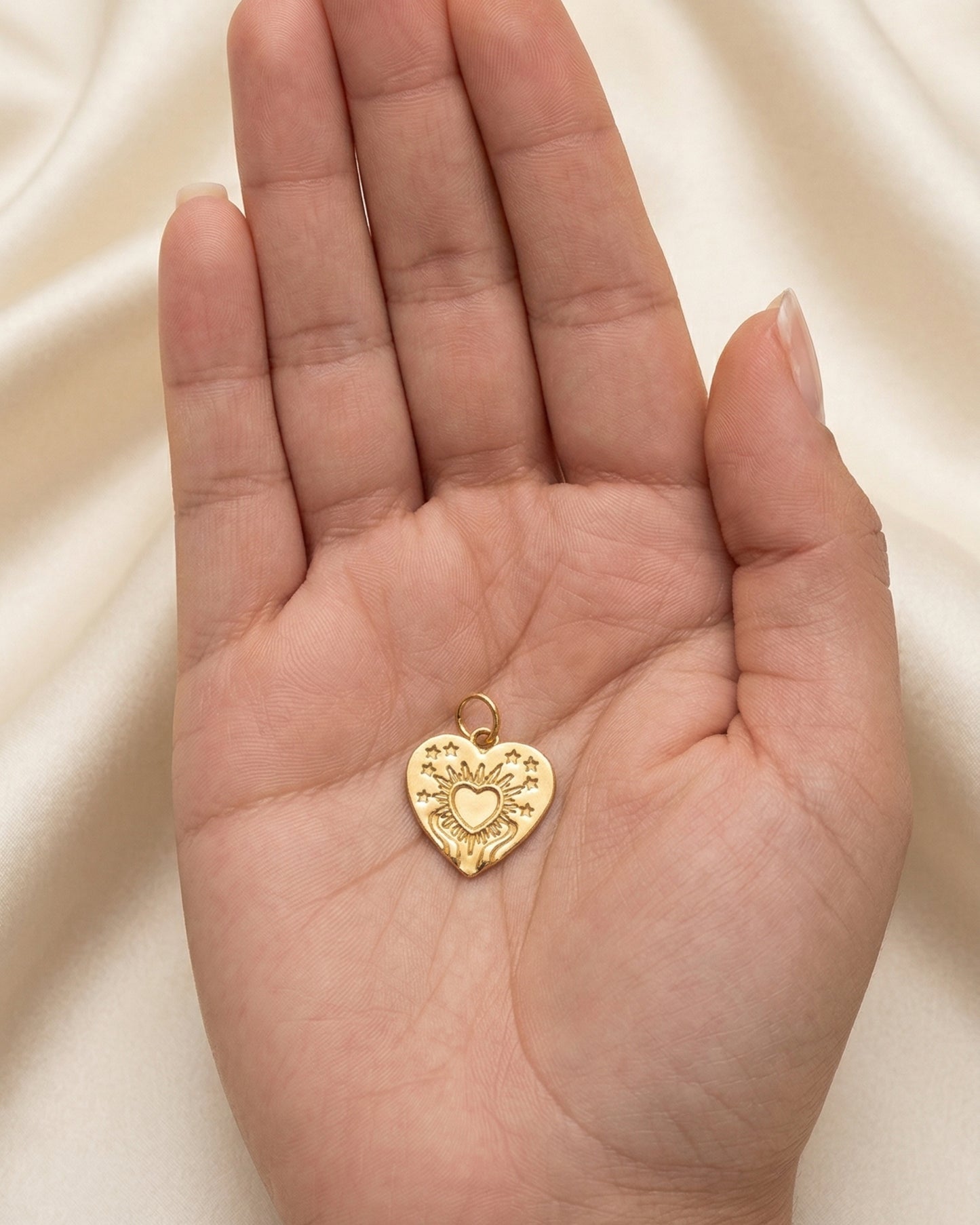 Dije medallón corazón sagrado con ráfagas de luz y estrellas