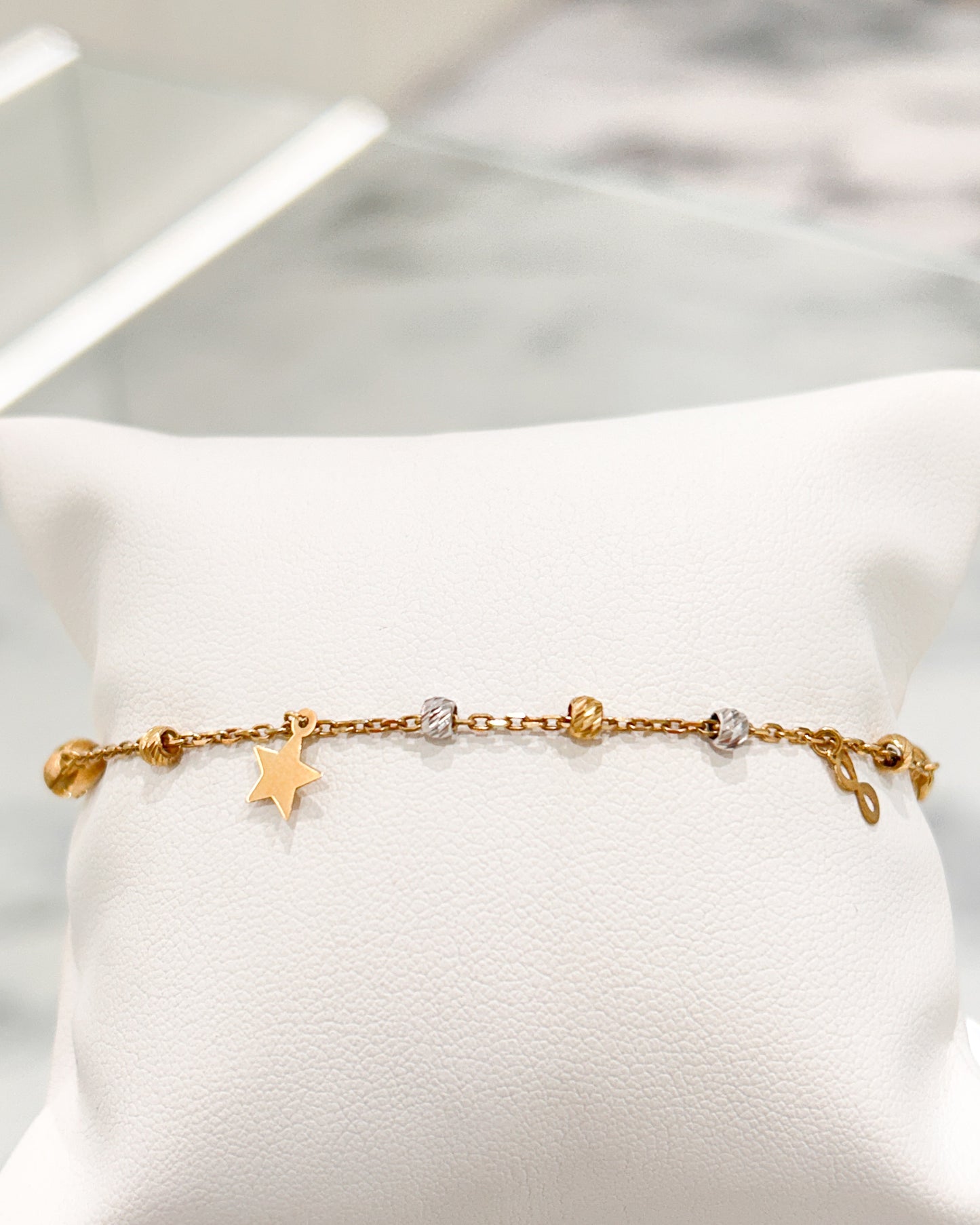 Pulsera de cadena fina con estrella, infinito y esferas en oro 10K