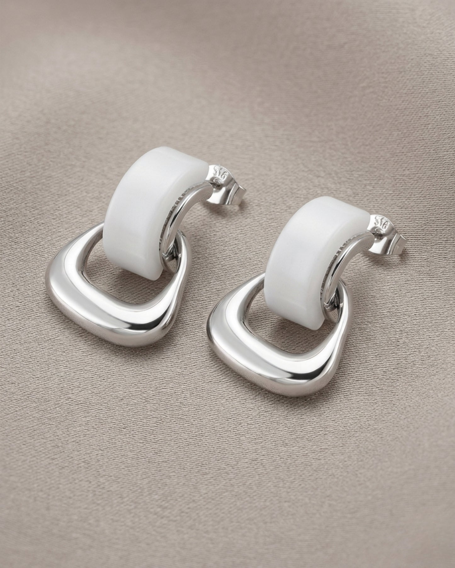Aretes tipo studs con aros entrelazados en plateado y blanco
