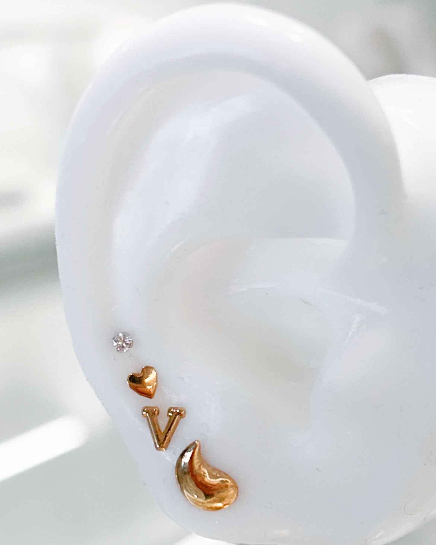 Arete tipo broquel de inicial "V" miniatura en oro 10k