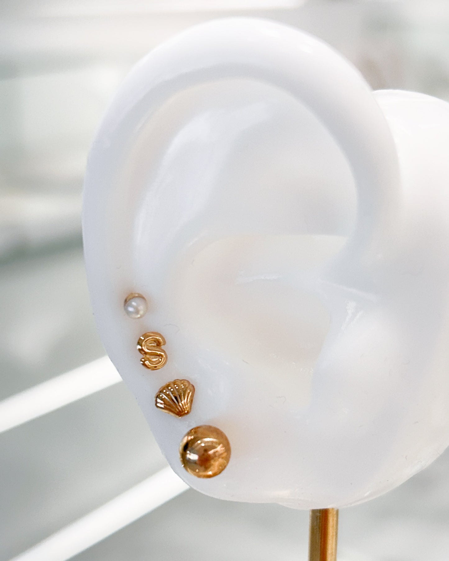 Arete tipo broquel de inicial "S" miniatura en oro 10k