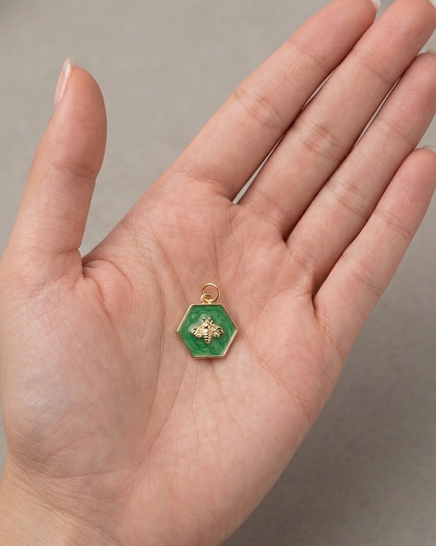Dije de medalla hexagonal en color verde con abeja color dorado en relieve