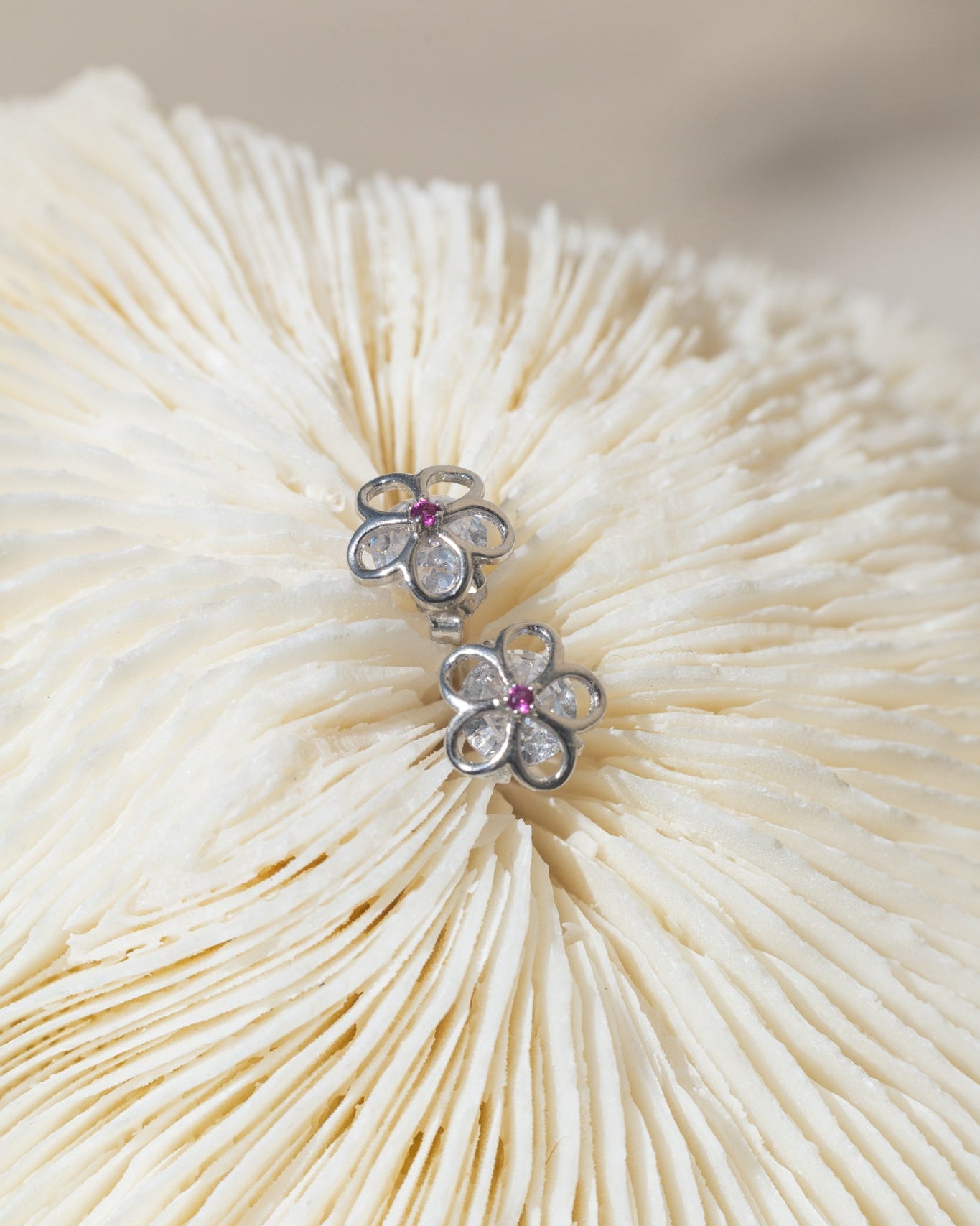 Broqueles en forma de flor con cristales claros y centro de rubí