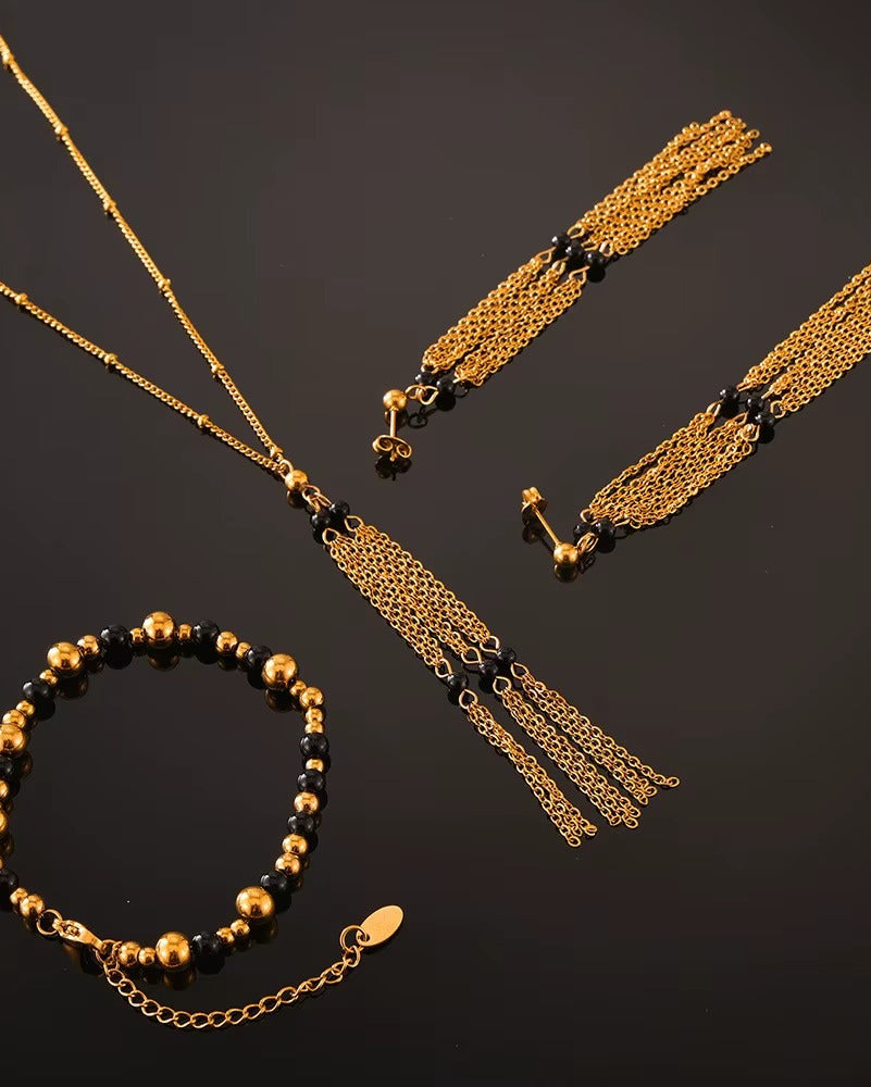 Arete bohemio en color dorado con negro, de tipo drop earrings.