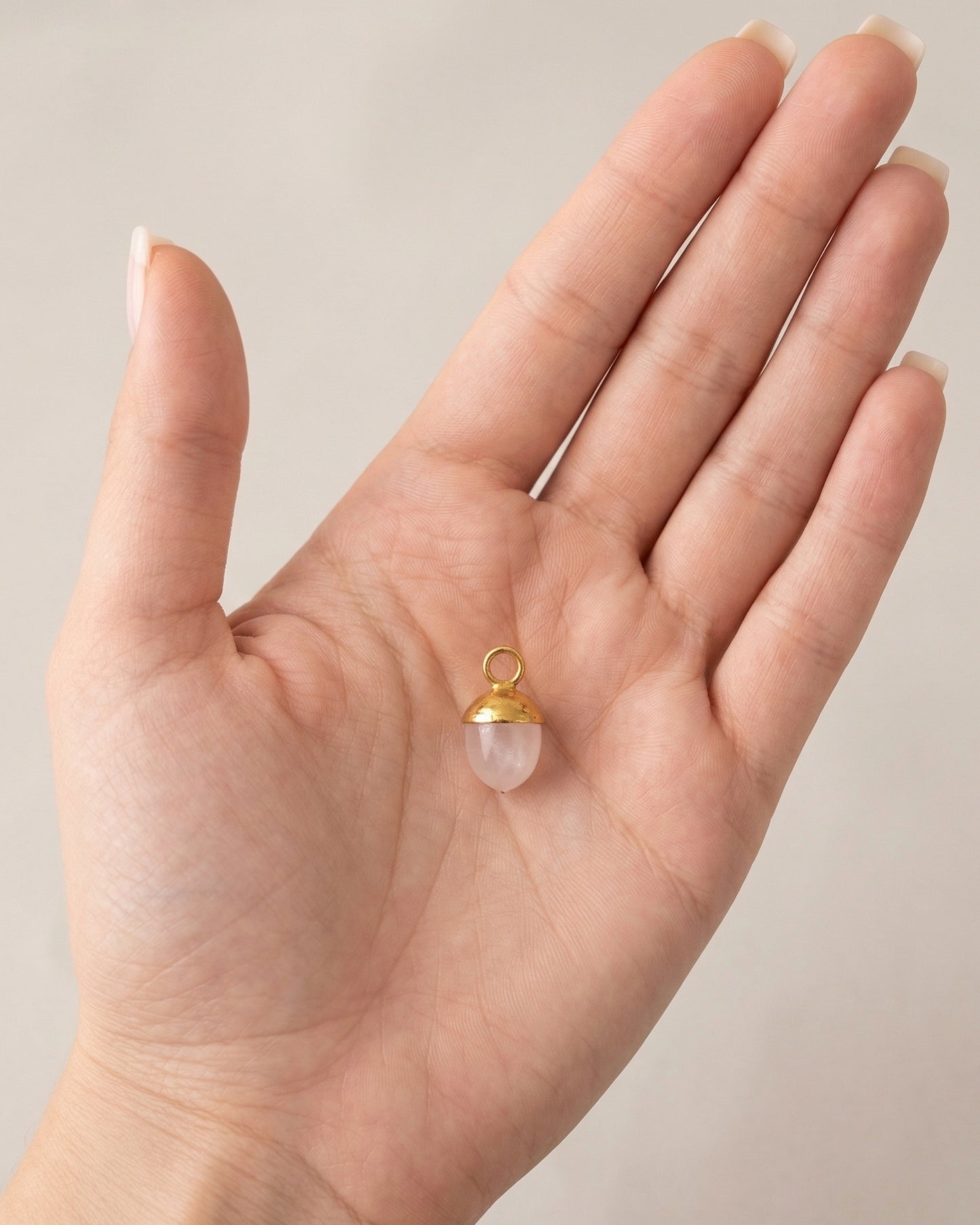Dije de cuarzo rosa con casquilla pulida en oro