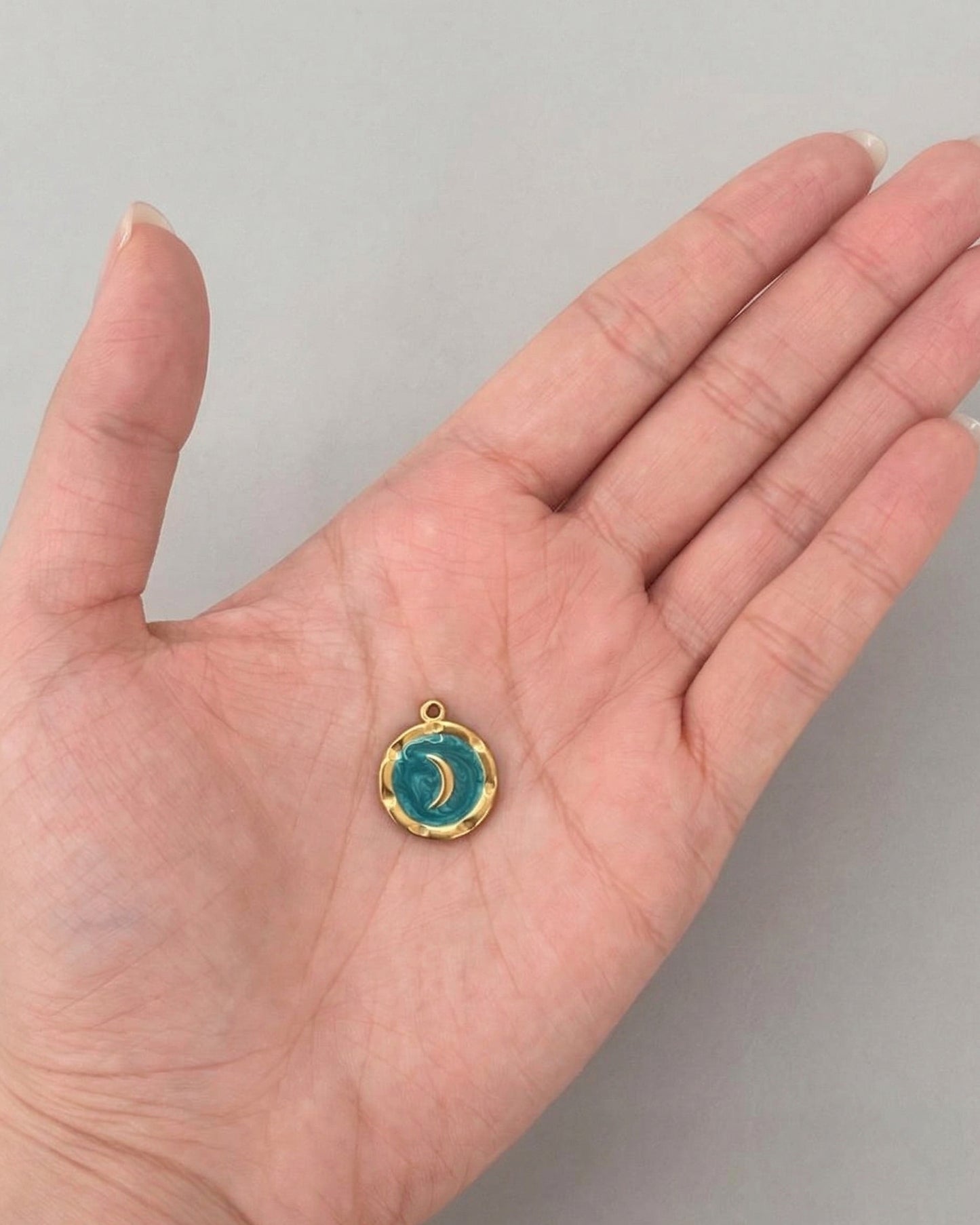 Dije de medalla dorada lunar con tonos turquesa