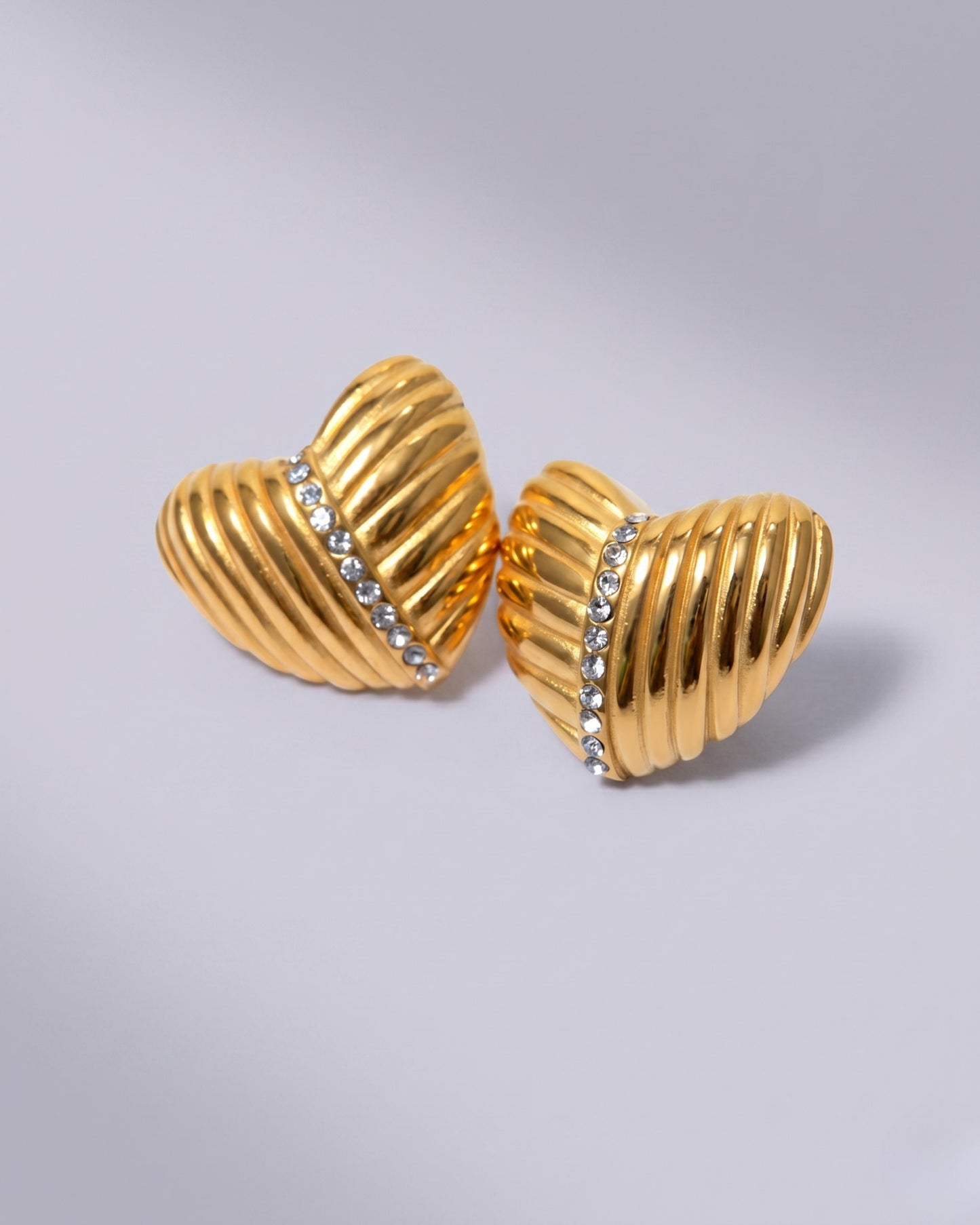 Aretes tipo studs de corazón con textura acanalada y cristales