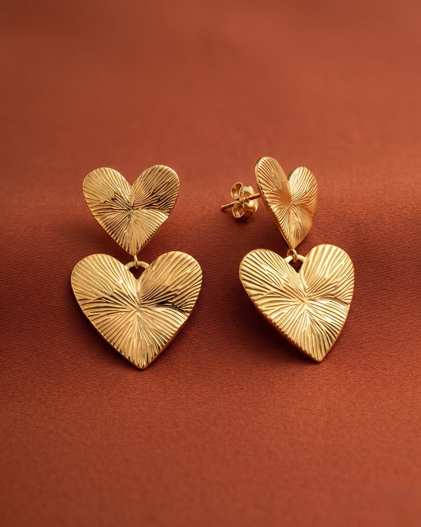 Aretes doble corazón con textura en relieve