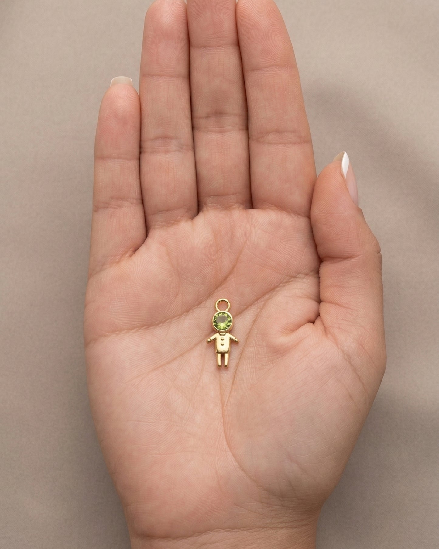 Dije figura de niño dorado "Little Guardian" con cristal verde