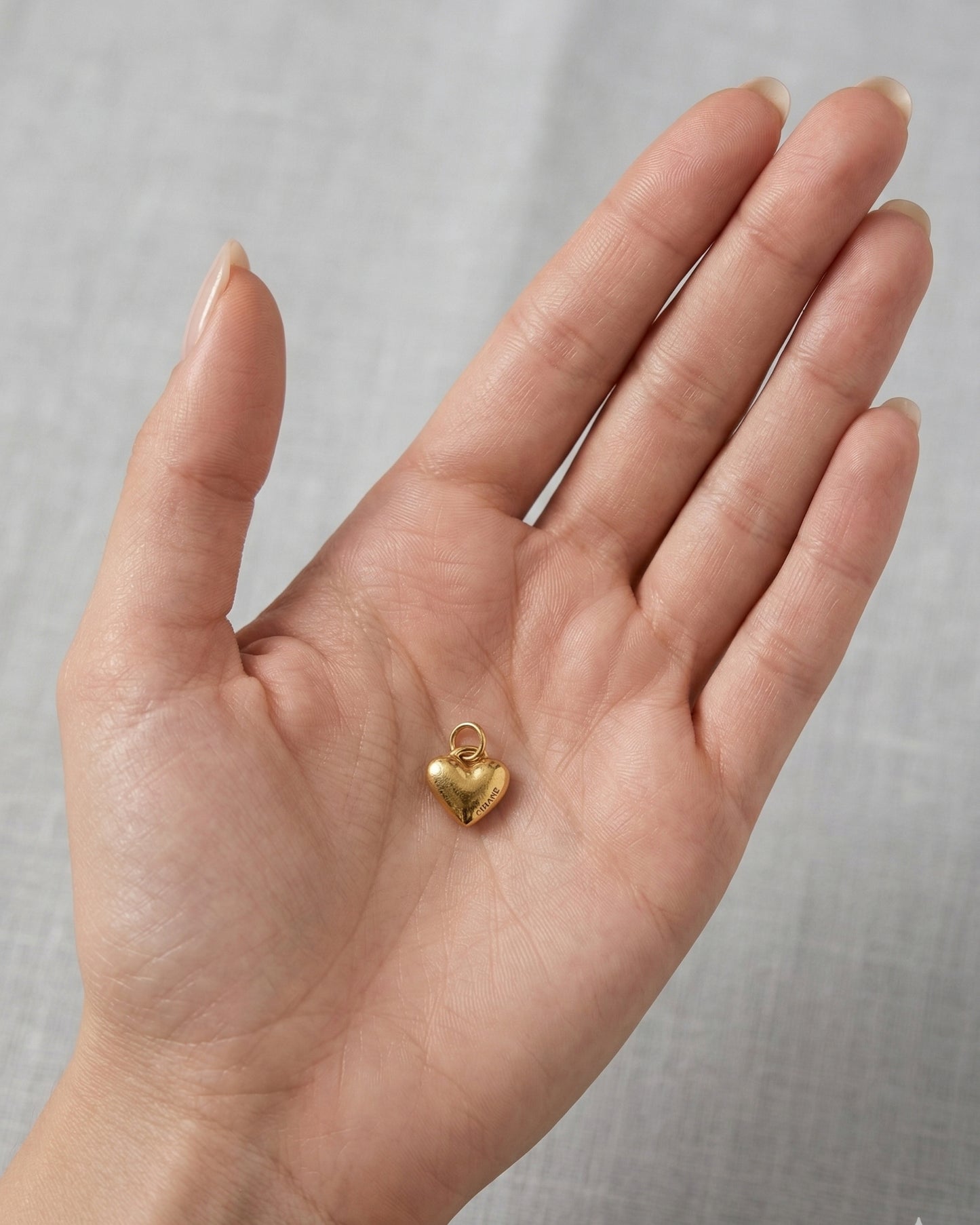 Dije de corazón abombado dorado con grabado