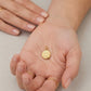 Dije de medalla circular dorada con corazón central y bisel grabado