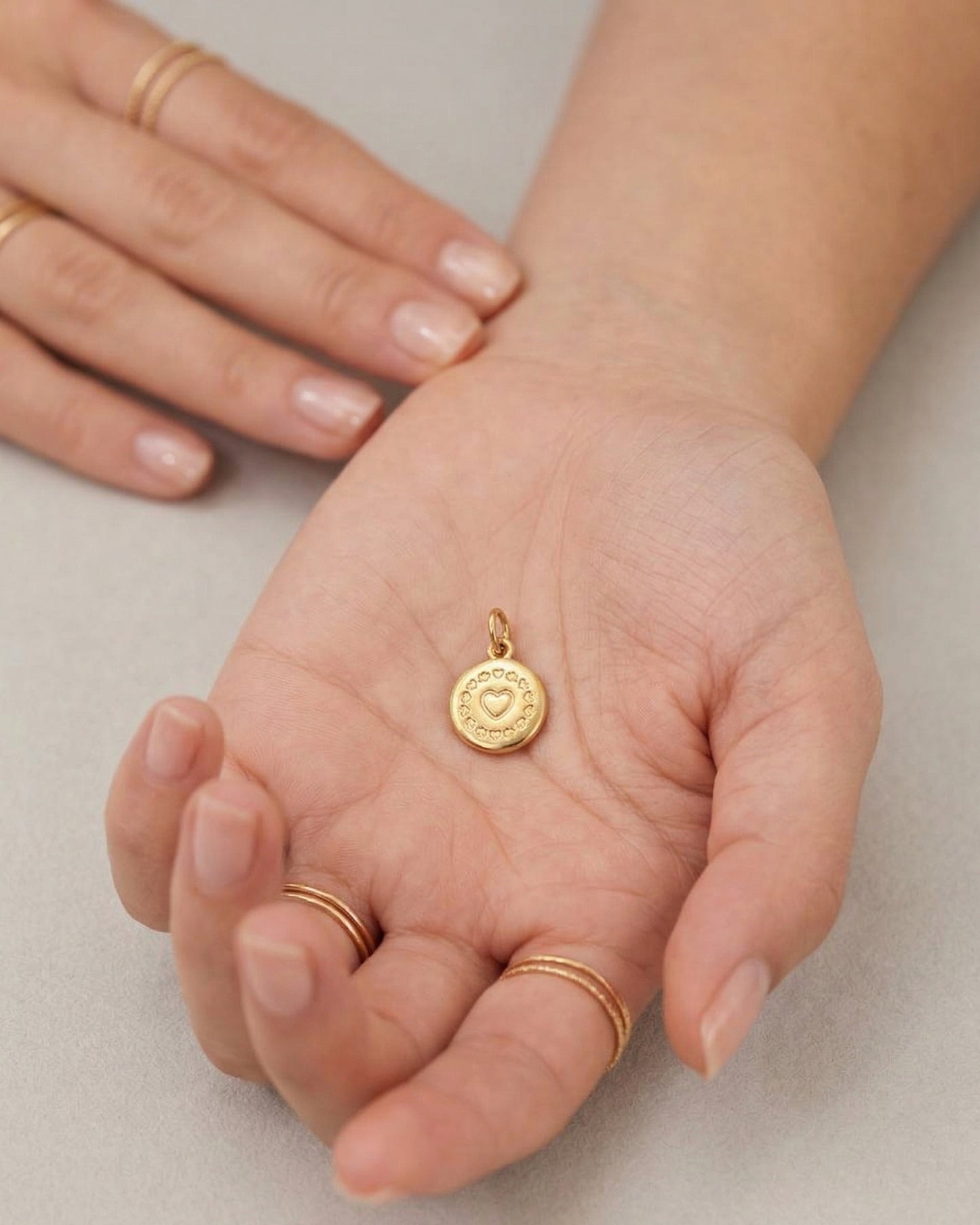 Dije de medalla circular dorada con corazón central y bisel grabado