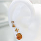 Arete tipo broquel de inicial "N" miniatura en oro 10k