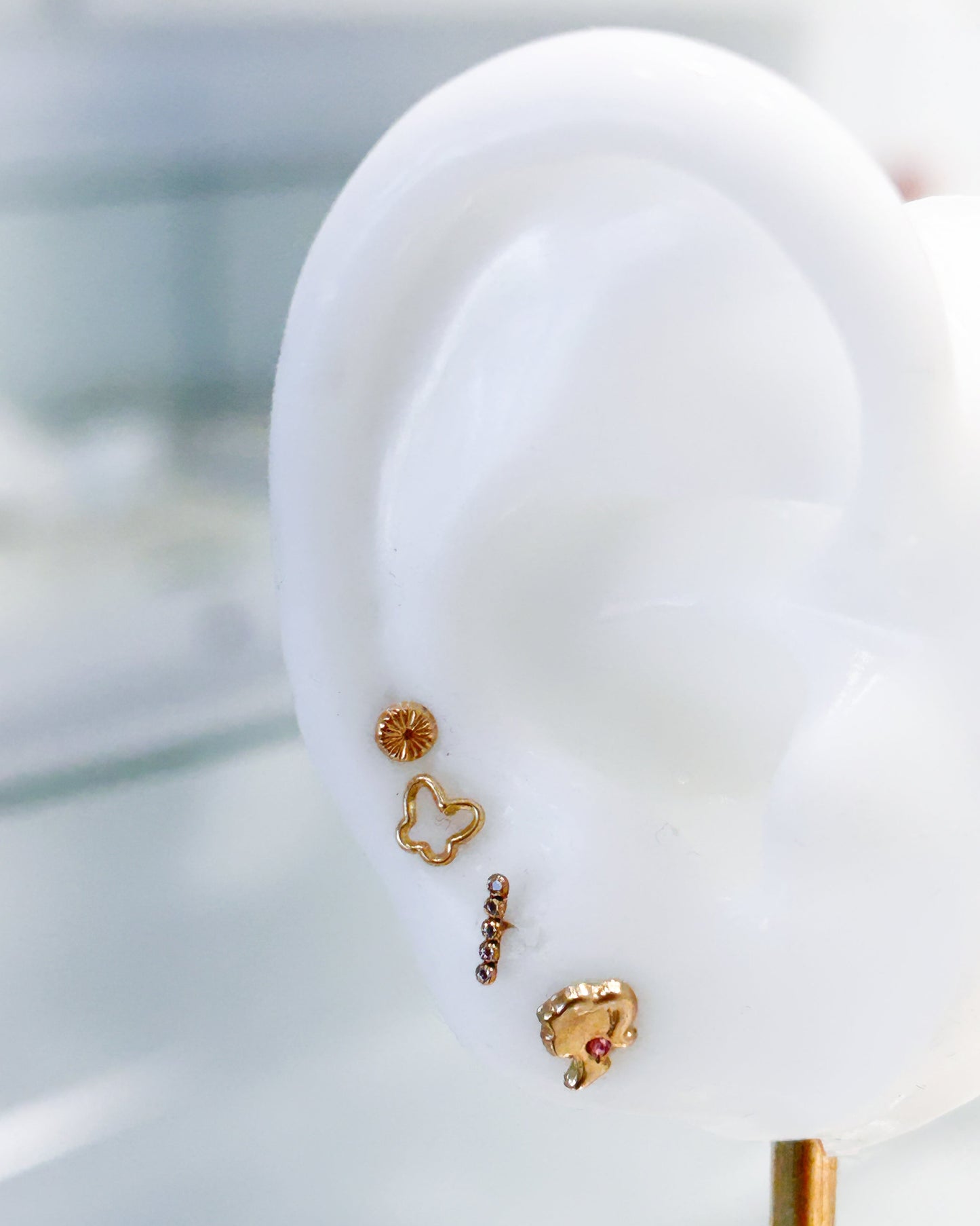 Arete tipo broquel de silueta de mariposa en oro 10k