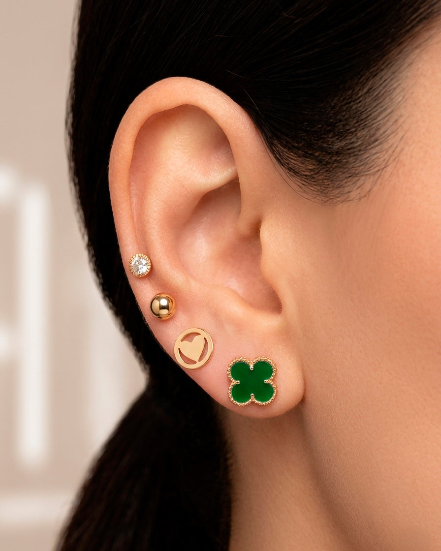 Arete tipo broquel de trébol con deposito de color verde en oro 10k