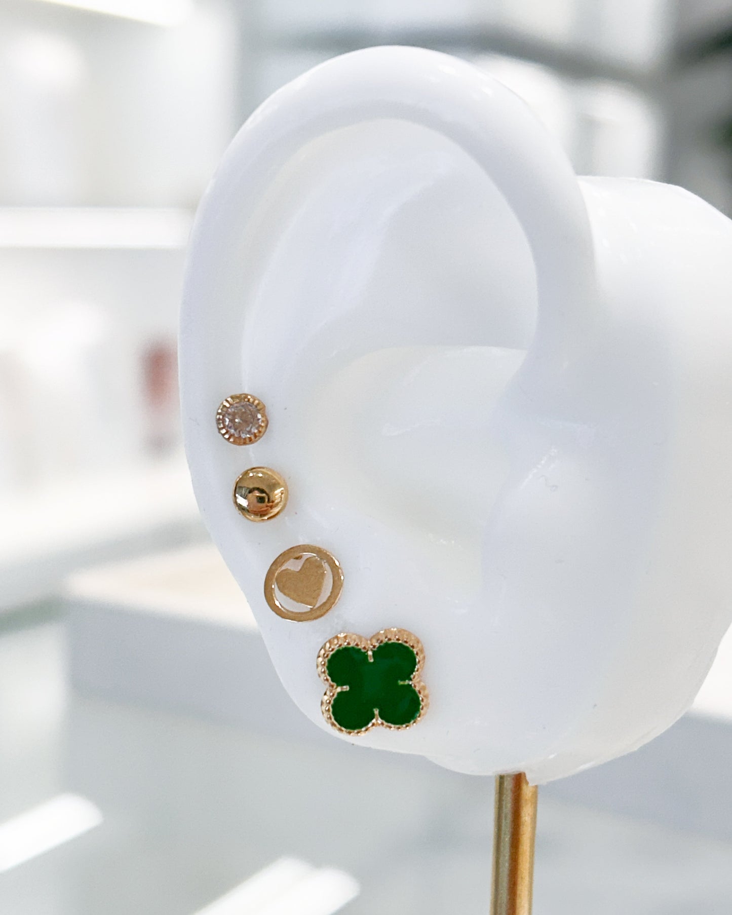 Arete tipo broquel de trébol con deposito de color verde en oro 10k