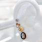 Arete tipo broquel de la Virgen de Guadalupe con deposito de color negro en oro 10k