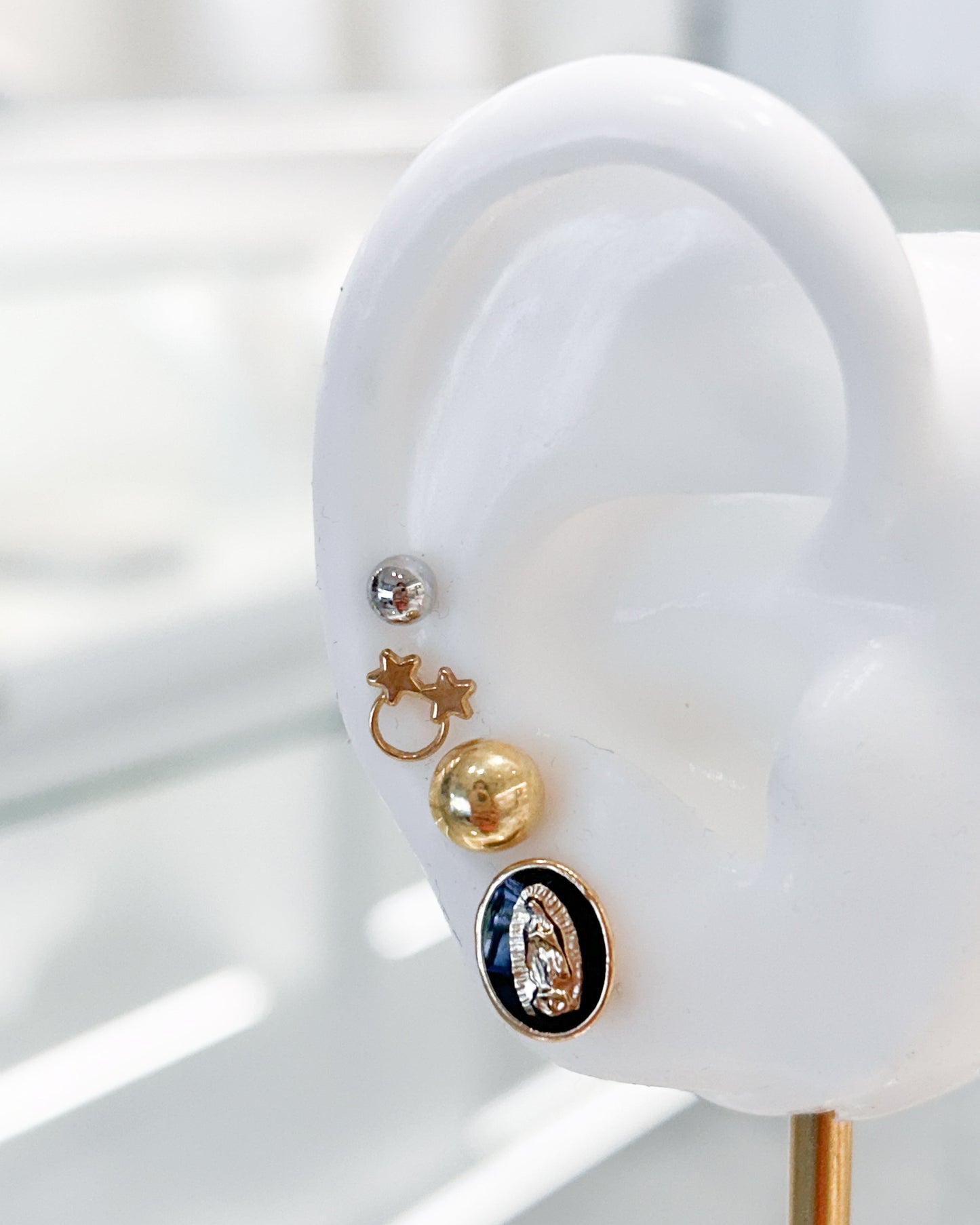 Arete tipo broquel de la Virgen de Guadalupe con deposito de color negro en oro 10k