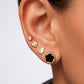 Arete tipo broquel circular con silueta de flor y fondo negro en oro 10k