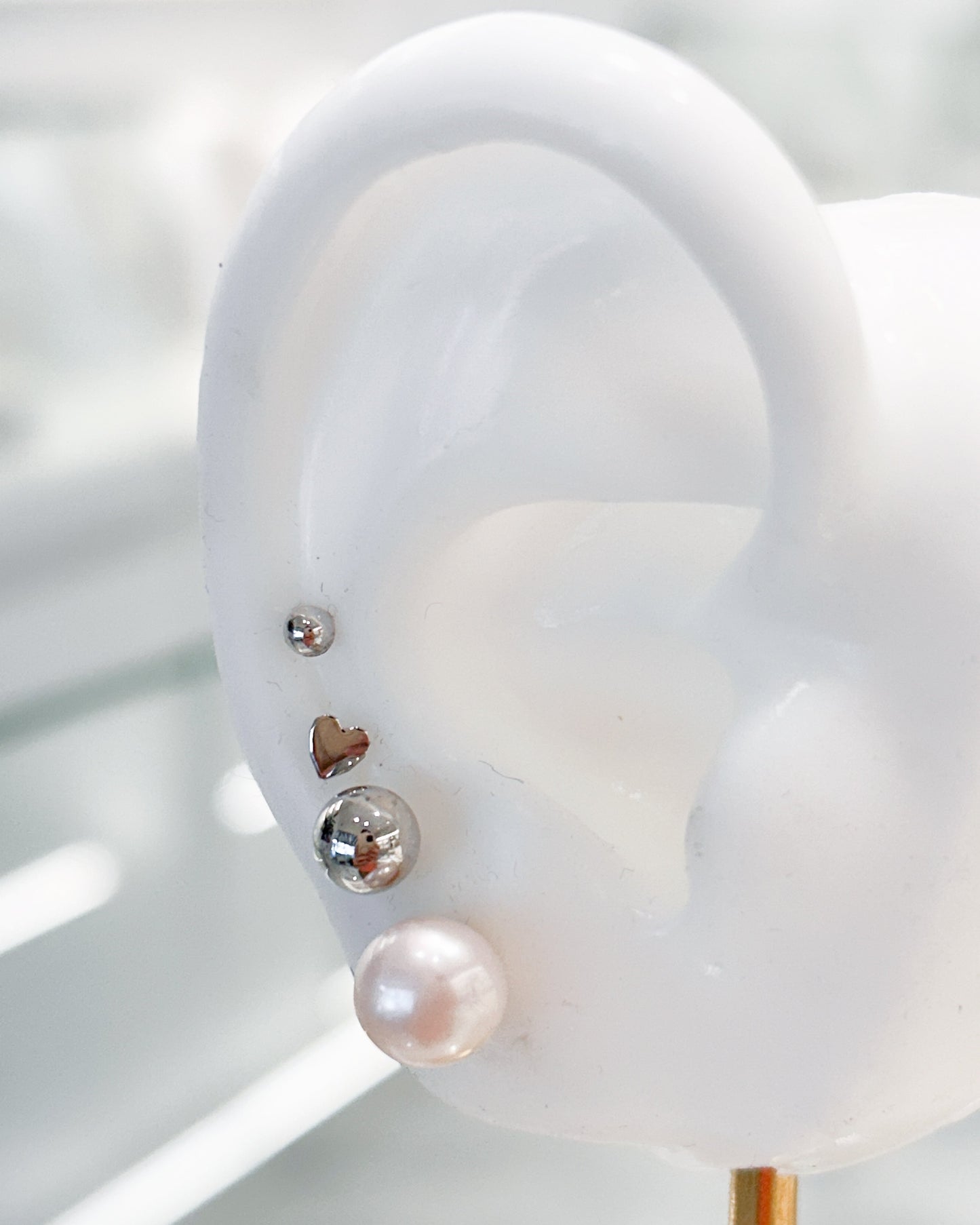 Arete tipo broquel de perla clásica con silueta esférica y brillo nacarado en oro 10k