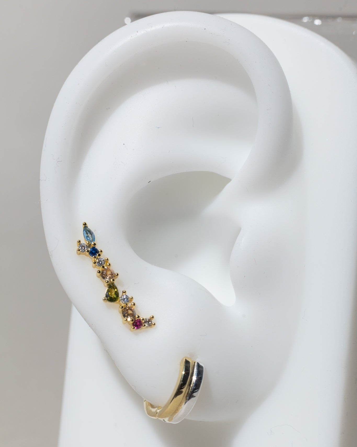 Arete dorado elegante con piedra circonias en distintos colores tipo ear climbers
