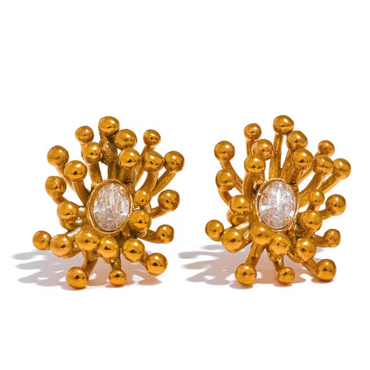 Aretes dorados con formas orgánicas inspiradas en los corales marinos, que irradian movimiento y textura. Su diseño escultórico rodea una piedra brillante central, creando un efecto luminoso y sofisticado. Ideales para destacar con estilo único.
