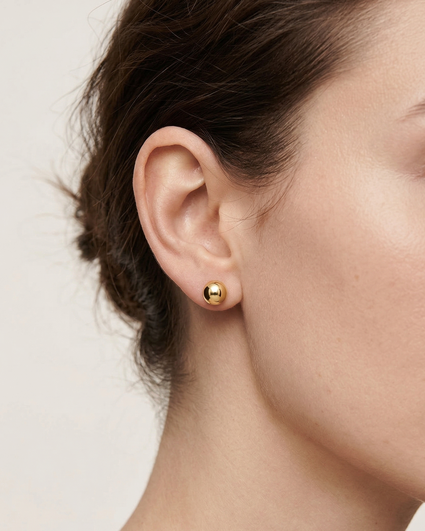 Aretes dorados con diseño de esfera de tipo broquel