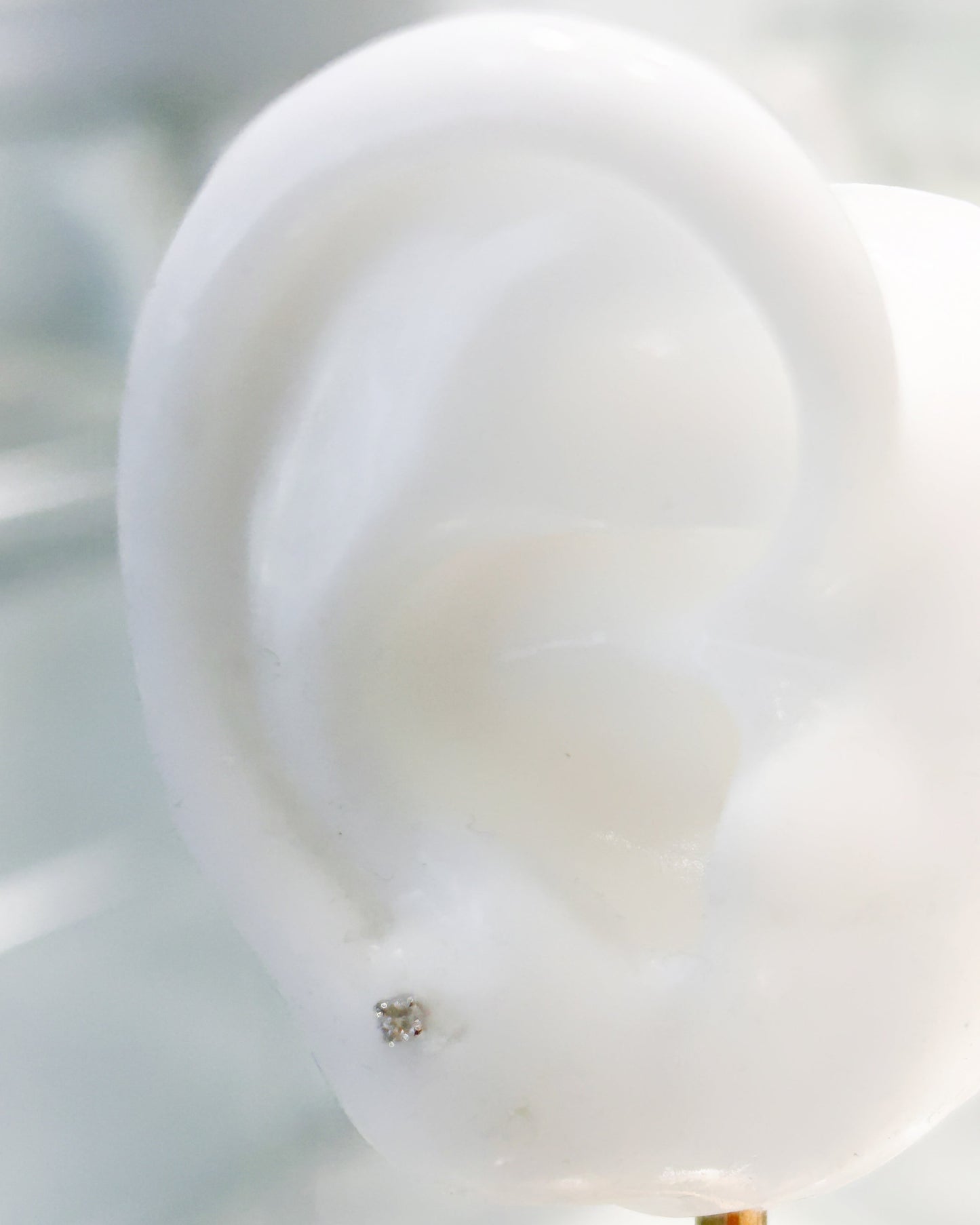 Arete tipo broquel en oro blanco 10k con diamante