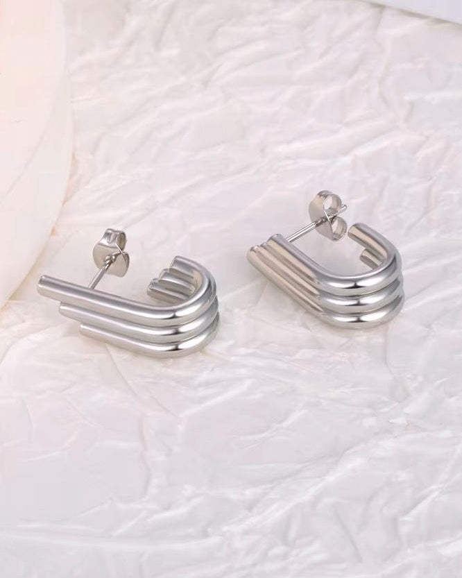 Aretes plateados de triple línea tubular con diseño asimétrico
