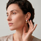 Aretes tipo studs con aros entrelazados en dorado y blanco