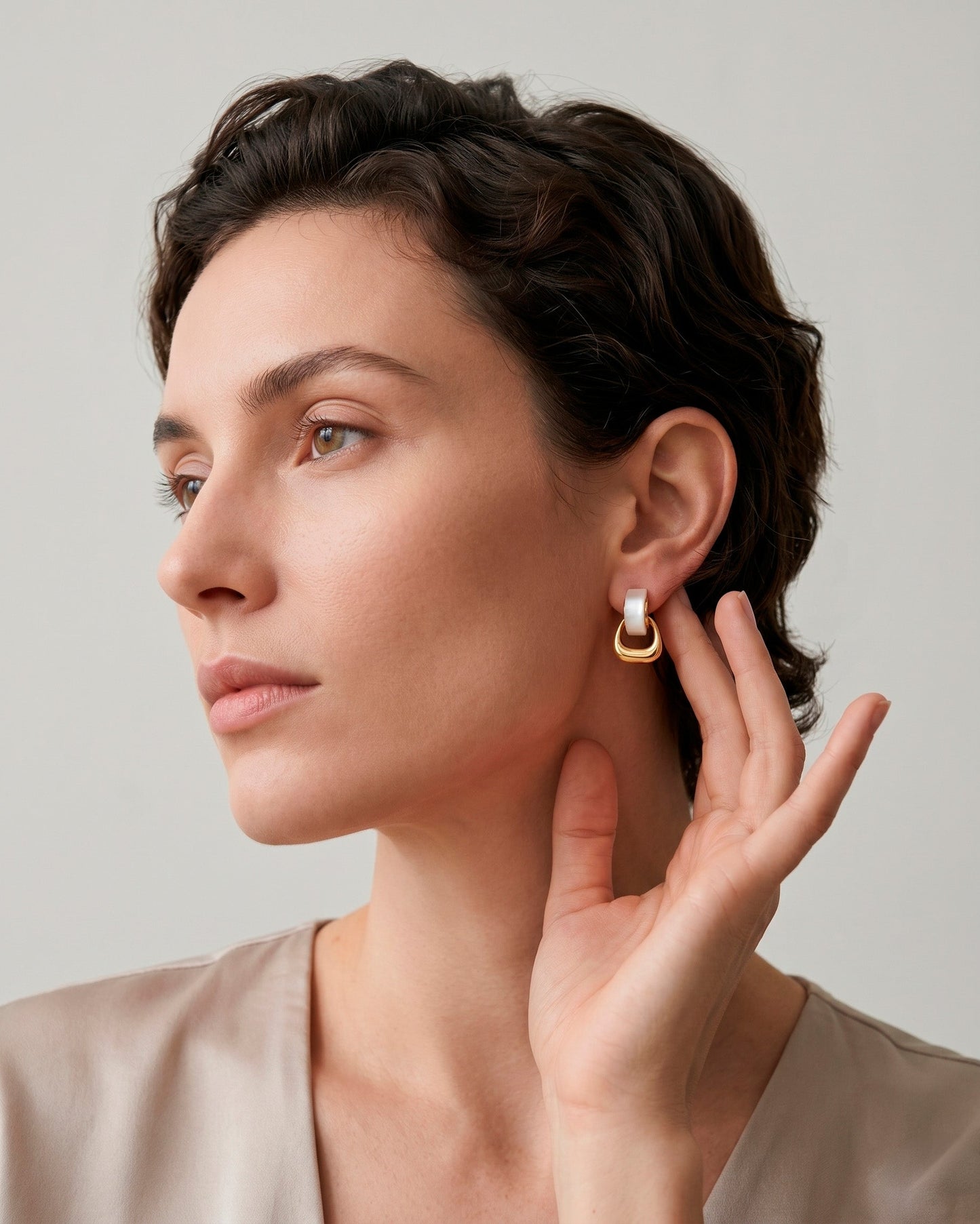 Aretes tipo studs con aros entrelazados en dorado y blanco