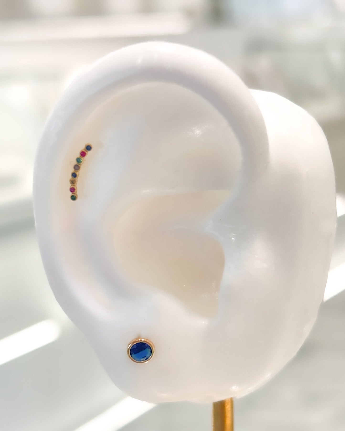 Arete tipo broquel trepadores con arcoíris de cristales en oro 10k