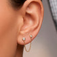Arete tipo broquel de doble punto con cadena colgante y circonias