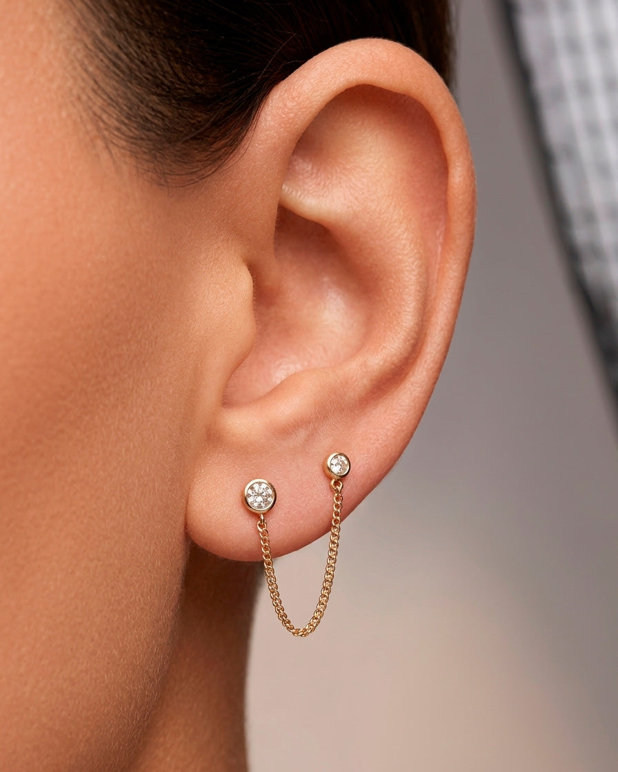 Arete tipo broquel de doble punto con cadena colgante y circonias