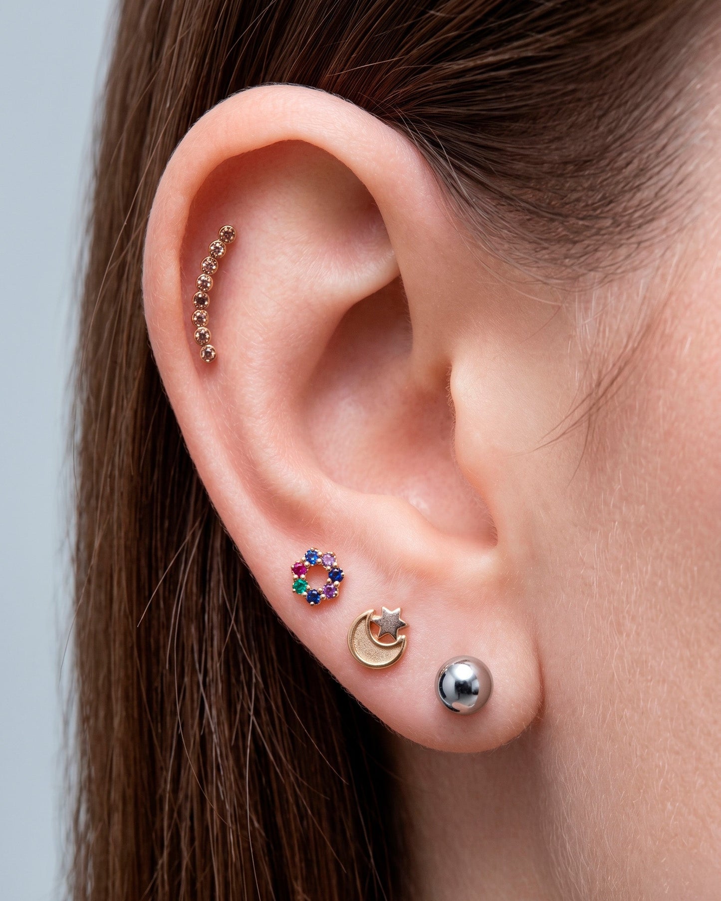 Arete tipo broquel trepadores con arco de cristales claros en oro 10k