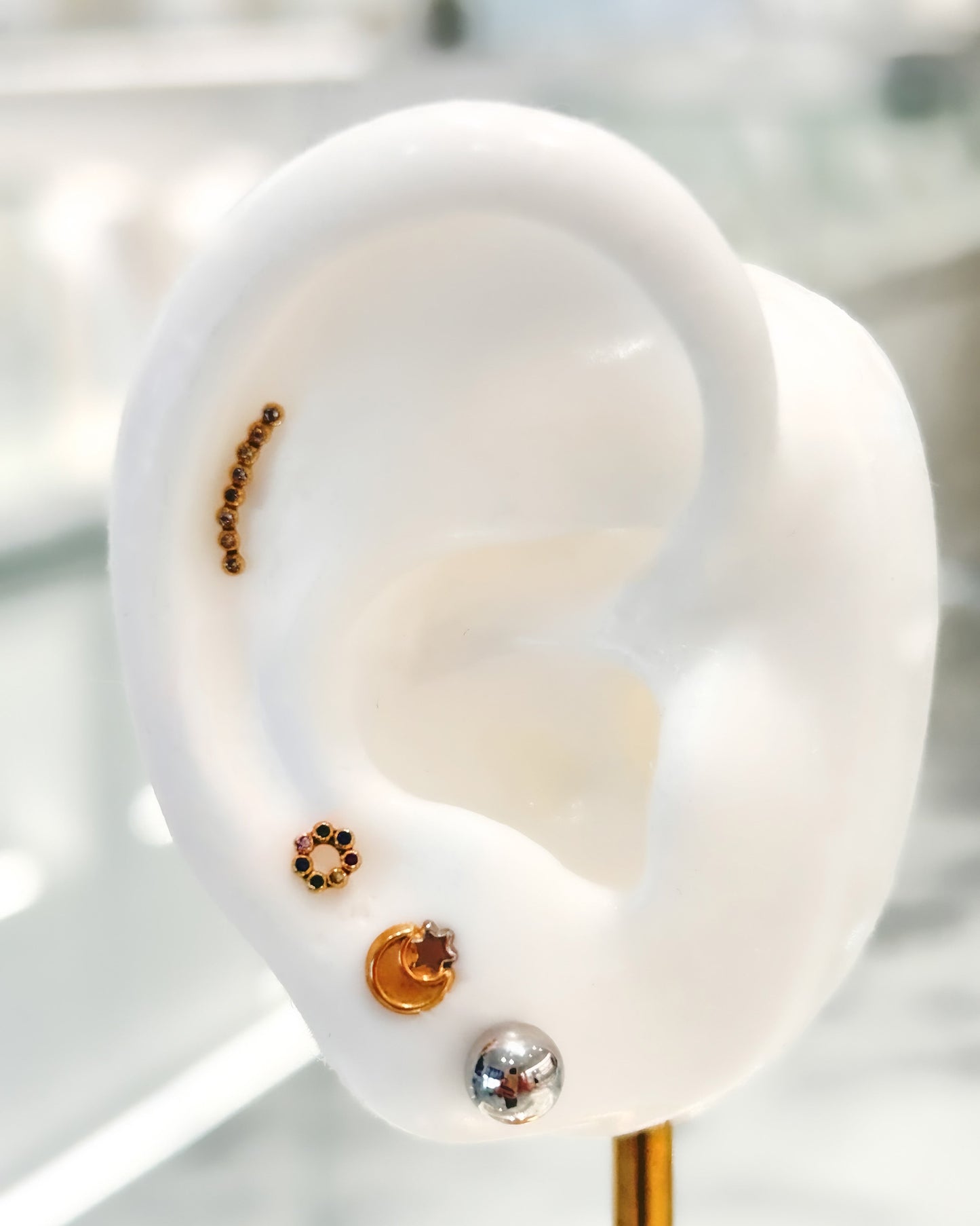 Arete tipo broquel trepadores con arco de cristales claros en oro 10k