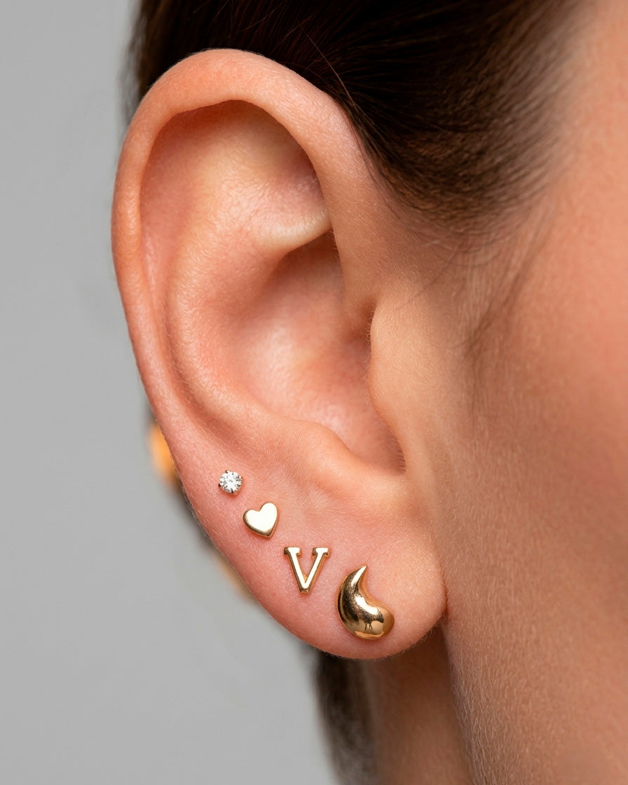Arete tipo broquel de inicial "V" miniatura en oro 10k