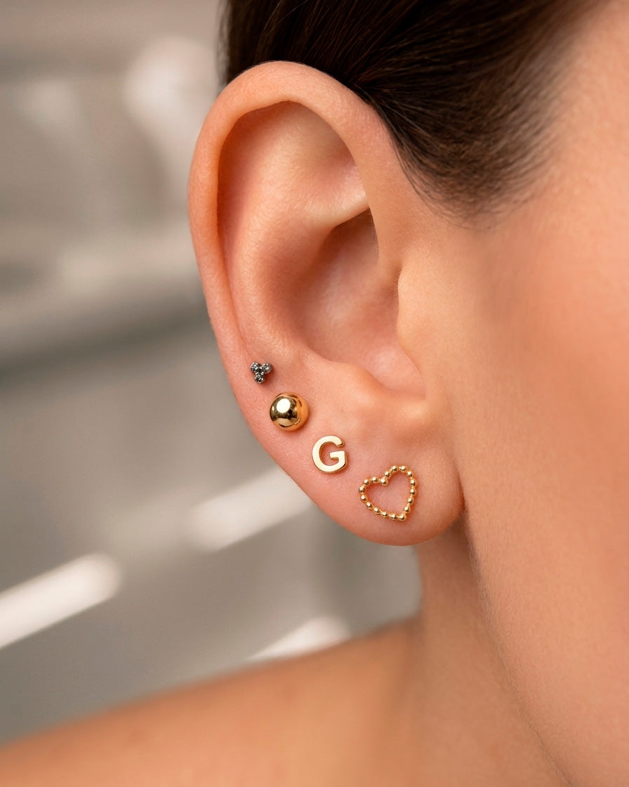 Arete tipo broquel de inicial "G" miniatura en oro 10k