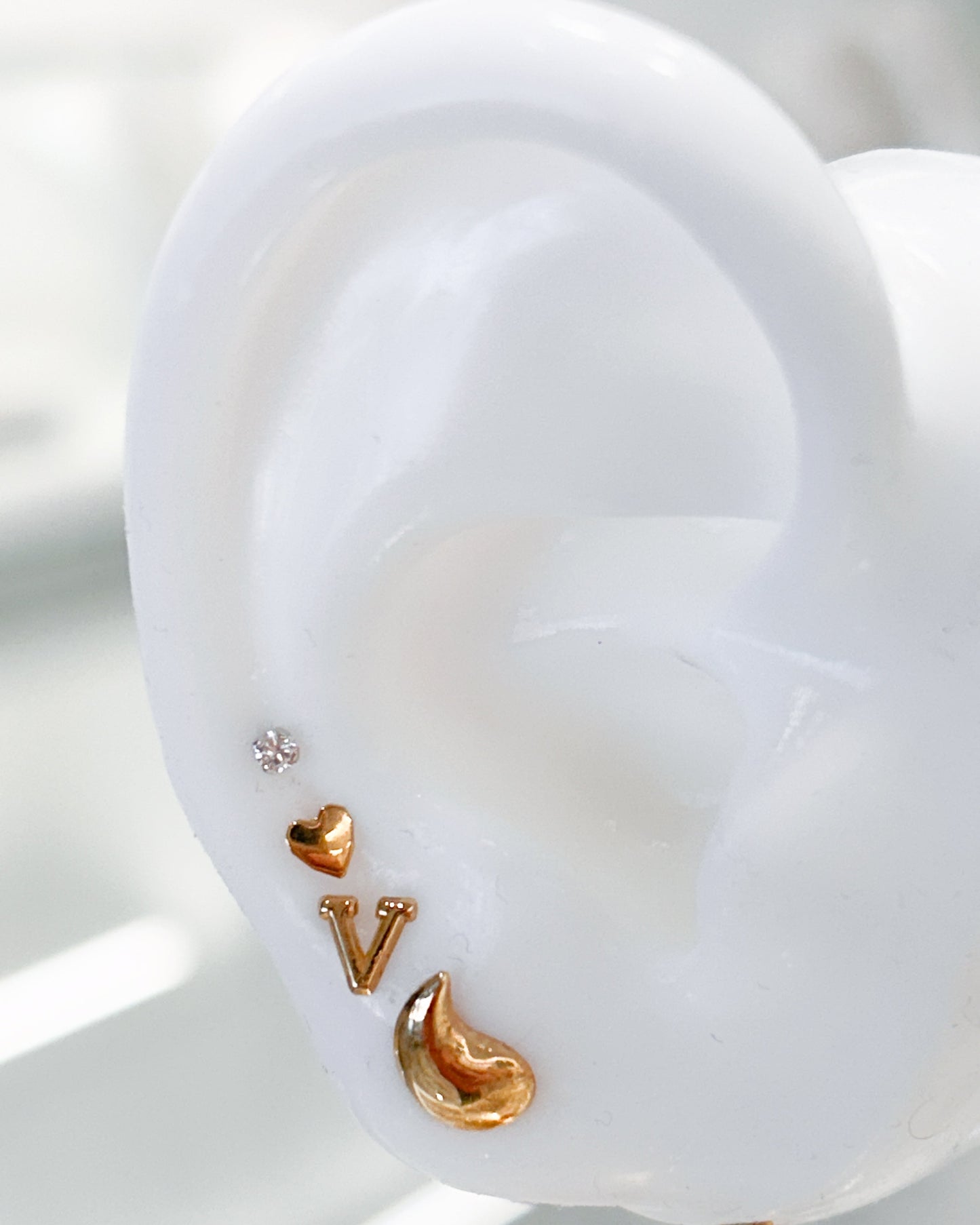 Arete tipo broquel de gota curva con acabado sólido en oro 10k