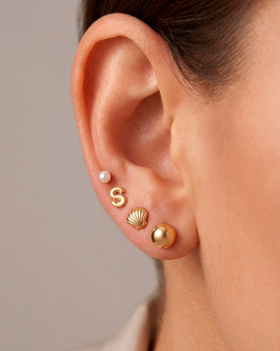 Arete tipo broquel de conchita de mar con textura en relieve en oro 10k