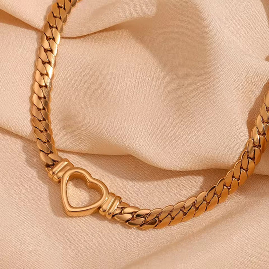 Elegante pulsera elaborada con cadena dorada tipo cubana, de acabado grueso, con un dije de corazón al centro. Su diseño sofisticado eleva cualquier look y se convierte en una verdadera declaración de estilo. Combínala con perlas y crea un contraste único.