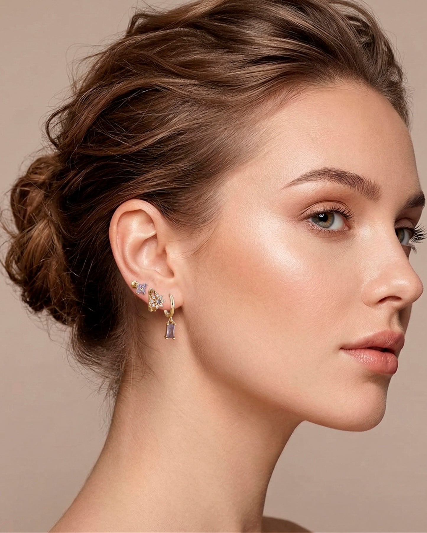 Mix de aretes dorados con diseño de mariposa, flor y piedra en tonos rosas