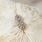 Broqueles en forma de flor con cristales claros y centro de rubí