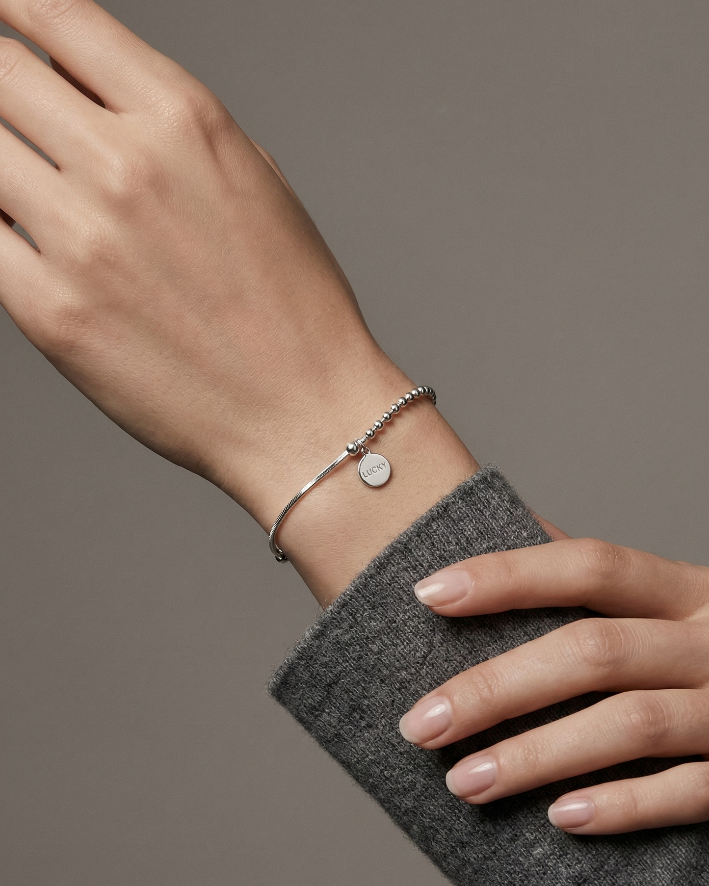 Pulsera de esferas y cordón plano con dije Lucky