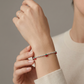 Pulsera de esferas plateadas con dijes de cereza en resina