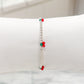 Pulsera de esferas plateadas con dijes de cereza en resina