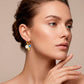 Aretes estilo huggies dorados de acero inoxidable con colgante de flor y piedras azul y amarilla