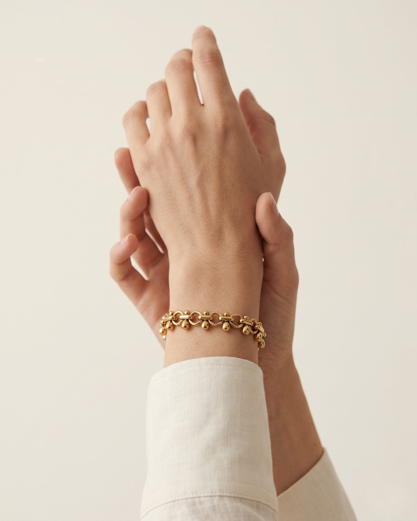 Pulsera de eslabones circulares con dijes de gota en dorado